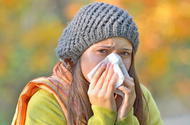 Girl sneezing with tissue