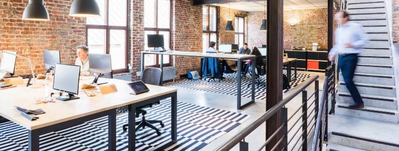 Employees at work in an open floor plan office in need of air purification.